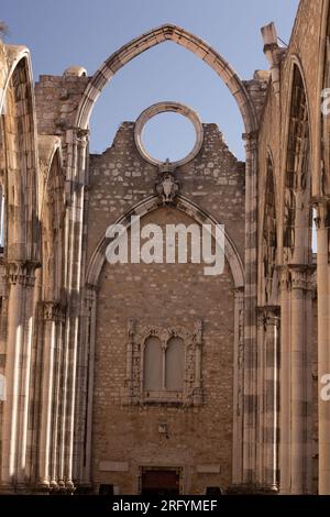 I sussurri della storia risuonano attraverso gli antichi archi del Convento do Carmo, uno scorcio ipnotico del passato e dello splendore architettonico di Lisbona Foto Stock