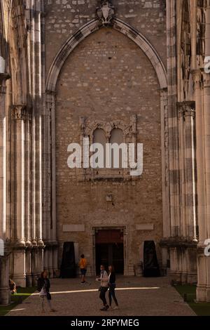 I sussurri della storia risuonano attraverso gli antichi archi del Convento do Carmo, uno scorcio ipnotico del passato e dello splendore architettonico di Lisbona Foto Stock