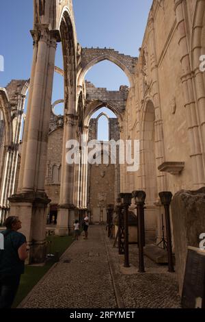 I sussurri della storia risuonano attraverso gli antichi archi del Convento do Carmo, uno scorcio ipnotico del passato e dello splendore architettonico di Lisbona Foto Stock