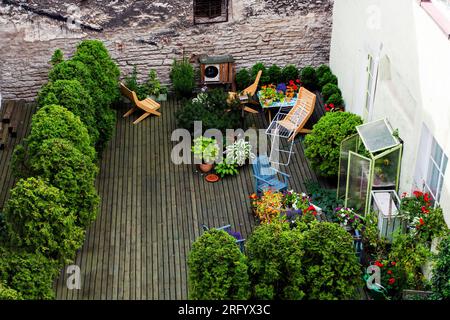 giardino verde con topi e fiori sul tetto di una casa in città in una giornata di sole. Vista dall'alto Foto Stock