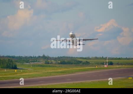 Helsinki / Finlandia - 5 AGOSTO 2023: Un aereo decolla dalla pista contro un cielo nuvoloso e luminoso. Foto Stock