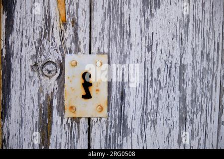 Tombino in metallo rustico per porte a forma di Z su A. primo piano della caratteristica vintage sullo sportello in legno grigio Foto Stock