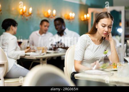 Donna sola al ristorante Foto Stock