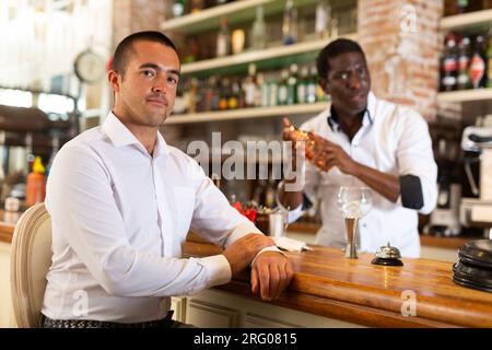 Visitatore seduto al bar Foto Stock