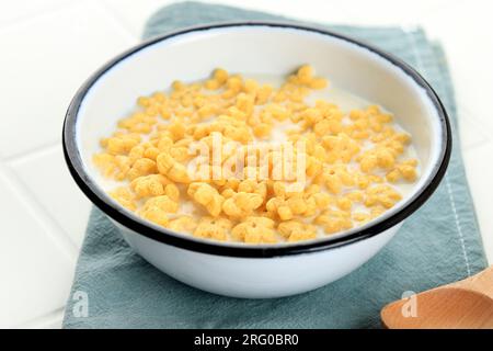 Miele Star Flakes con latte per colazione, su tavolo bianco Foto Stock