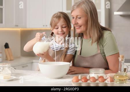 Nonna felice con sua nipote che cucinava insieme in cucina Foto Stock