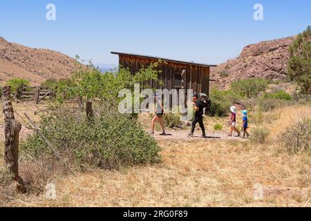 Escursioni per giovani famiglie attraverso il campo minerario abbandonato sulle pendici dorate delle montagne Organ Mountains-Desert Peaks National Monument Foto Stock