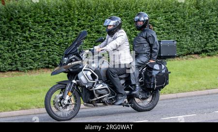 Whittlebury, Northants., UK - 6 agosto 2023. Turisti spagnoli in sella a una BMW R 1250 GS attraverso un villaggio inglese. Foto Stock