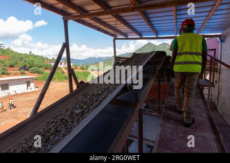 Il minerale frantumato viene smistato in un tappetino durante l'estrazione industriale dell'oro Foto Stock