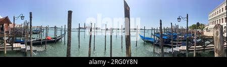 Vista con le gondole ormeggiate attraverso la laguna veneziana da Piazza San Marco a Venezia verso la chiesa di San Giorgio maggiore Foto Stock