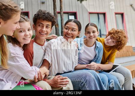 donna afroamericana positiva che tiene per mano studenti adolescenti, diversità, insegnante, studio Foto Stock