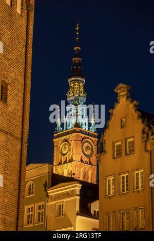 La torre principale del municipio e le case storiche di notte nella città di Danzica, Polonia. Architettura gotica e rinascimentale nella città vecchia. Foto Stock