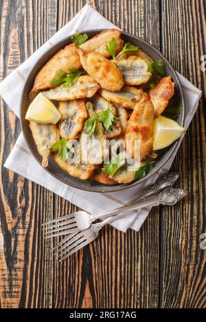 Sano antipasto mediterraneo o greco di acciughe fritte in pastella primo piano sul tavolo. Vista dall'alto verticale Foto Stock