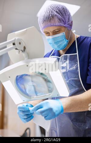 Un assistente di laboratorio conduce ricerche con biomateriali in laboratorio. Foto Stock