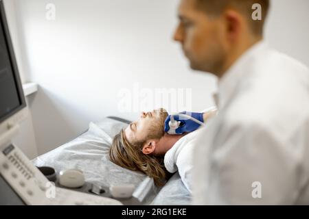 Uomo durante una diagnosi ecografica dell'arteria carotide Foto Stock