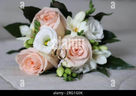 Due fedi nuziali esposti nel bouqet della sposa Foto Stock