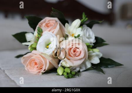 Due fedi nuziali esposti nel bouqet della sposa Foto Stock