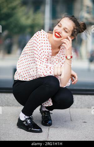 Giovane bella donna con rossetto rosso che si accosta Foto Stock