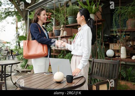 Persone diverse che si stringono la mano prima di discutere Foto Stock
