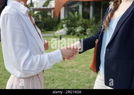 Immagine ritagliata di donne che si stringono la mano quando si salutano Foto Stock