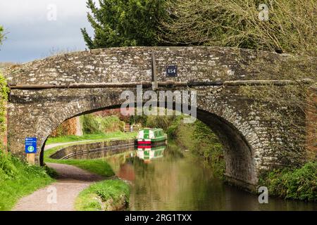 Ammira il vecchio ponte 154 fino alla barca stretta ormeggiata da un sentiero sul Monmouthshire e sul Brecon Canal. Pencelli, Brecon, Powys, Galles, Regno Unito, la Gran Bretagna Foto Stock