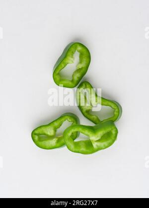 Peperoni verdi a fette su sfondo bianco fette di peperoncino verde su sfondo bianco Foto Stock