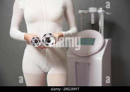 Una donna che mostra gli accessori di una macchina dimagrante alla  cavitazione, al sollevamento rf e al trattamento a vuoto Foto stock - Alamy