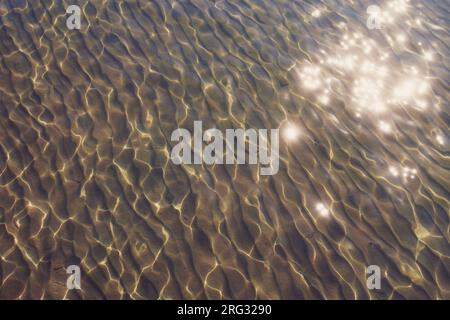 Superficie dell'acqua di mare con riflessi solari Foto Stock