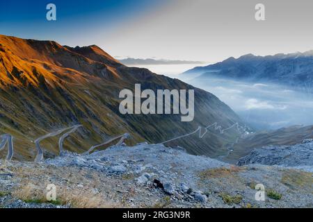Passo dello Stelvio con montagne innevate e una strada tortuosa nella valle Foto Stock
