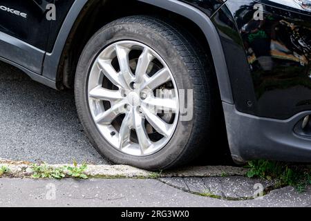 OSTRAVA, REPUBBLICA CECA - 17 LUGLIO 2023: Pneumatico Gripmax stature M S su jeep SUV danneggiato e schiacciato da un parcheggio errato sul bordo del marciapiede Foto Stock