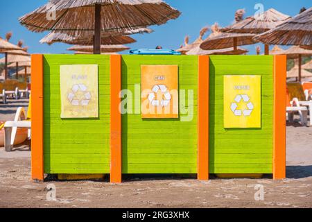 Contenitori per rifiuti per la raccolta di materiali riciclati. Separazione dei rifiuti. Vetro, carta e lattina separati per la raccolta dei rifiuti sulla spiaggia Foto Stock