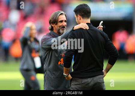 LONDRA, Regno Unito - 6 agosto 2023: L'allenatore del Manchester City fitness Lorenzo Buenaventura parla con il manager dell'Arsenal Mikel Arteta dopo il tappeto fa Community Shield Foto Stock