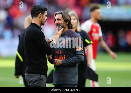 LONDRA, Regno Unito - 6 agosto 2023: L'allenatore del Manchester City fitness Lorenzo Buenaventura parla con il manager dell'Arsenal Mikel Arteta dopo il tappeto fa Community Shield Foto Stock