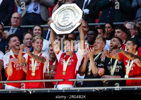 LONDRA, Regno Unito - 6 agosto 2023: Martin Odegaard dell'Arsenal solleva il trofeo e celebra la vittoria dei suoi compagni di squadra dopo l'fa Community Shield Foto Stock