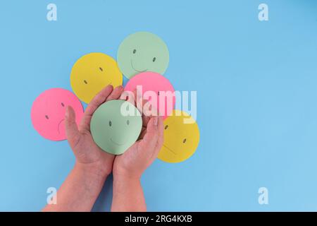 Pensiero positivo, salute mentale, capacità di vivere senza stress concetto. giornata mondiale di salute mentale sfondo. Emoticon di carta multicolore con Different Foto Stock