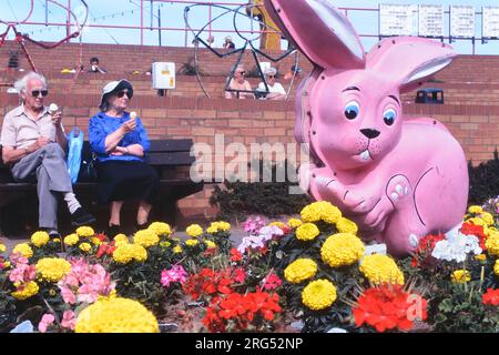 Coppia anziana seduta lungo il lungomare a mangiare gelati. Mablethorpe. Lincolnshire. Inghilterra. REGNO UNITO Foto Stock