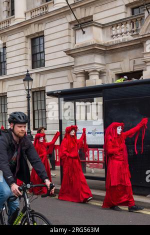 Londra, Regno Unito, 2023. Su Whitehall, i membri della compagnia di performance Red Rebel Brigade marciano verso Westminster per unirsi alla protesta di massa Foto Stock