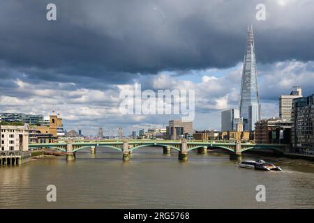 Londra, Regno Unito - 28 luglio 2023; vista a est lungo il Tamigi a Londra del Southwark Bridge e dello Shard nel giorno tempestoso Foto Stock