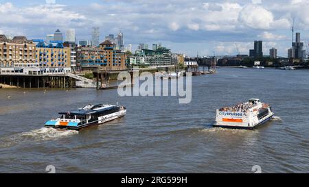 Londra, Regno Unito - 29 luglio 2023; due barche fluviali passeggeri che viaggiano a est sul Tamigi a Londra gestite da Uber Boat e City Cruises Foto Stock