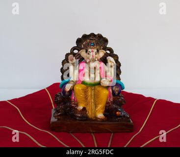 idol o statua di Dio Ganesh in mano con sfondo rosso . Biglietto d'auguri Happy Ganesh Chaturthi con spazio per fotocopie. Foto Stock