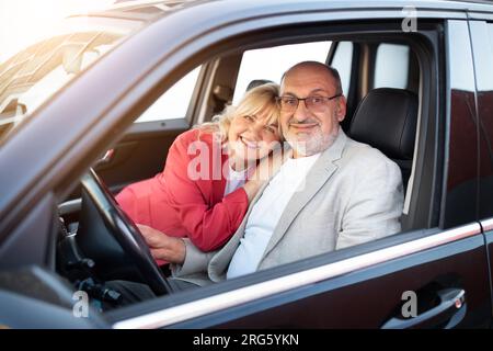 Auto di proprietà. Ritratto di una coppia anziana felice seduta nella loro nuova automobile Foto Stock
