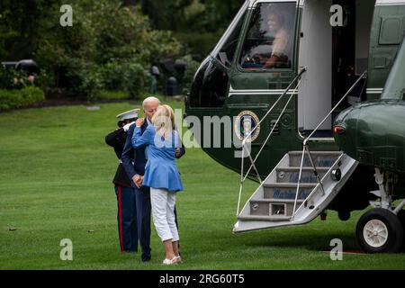 Con il pilota Marine One sorridente dall'alto, il presidente degli Stati Uniti Joe Biden bacia sua moglie, la first lady Jill Biden, mentre arrivano da Wilmington, Delaware sul South Lawn della Casa Bianca a Washington, DC, lunedì 7 agosto 2023. Credito: Rod Lamkey/CNP Foto Stock