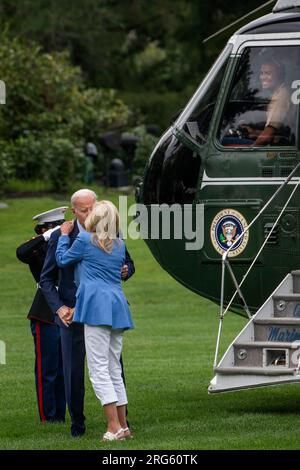 Con il pilota Marine One sorridente dall'alto, il presidente degli Stati Uniti Joe Biden bacia sua moglie, la first lady Jill Biden, mentre arrivano da Wilmington, Delaware sul South Lawn della Casa Bianca a Washington, DC, lunedì 7 agosto 2023. Credito: Rod Lamkey/CNP Foto Stock