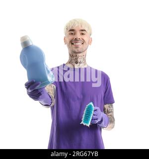 Giovane tatuato con bottiglia di detergente e spazzolina per la pulizia su sfondo bianco Foto Stock
