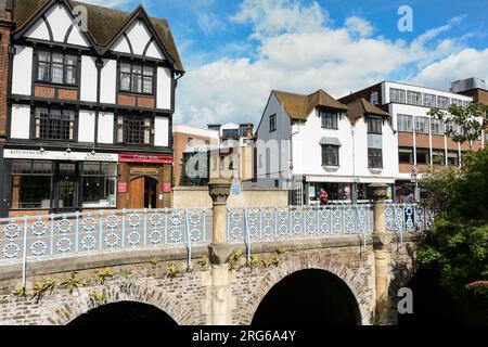 Edifici che circondano il Clattern Bridge mentre passa sopra il fiume Hogsmill a Kingston, Surrey, Inghilterra, Regno Unito Foto Stock