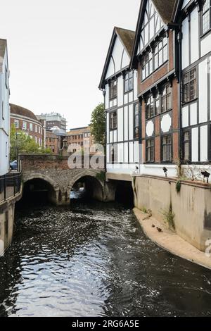 Edifici che circondano il Clattern Bridge mentre passa sopra il fiume Hogsmill a Kingston, Surrey, Inghilterra, Regno Unito Foto Stock