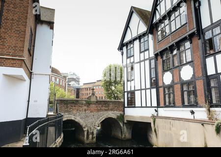 Edifici che circondano il Clattern Bridge mentre passa sopra il fiume Hogsmill a Kingston, Surrey, Inghilterra, Regno Unito Foto Stock