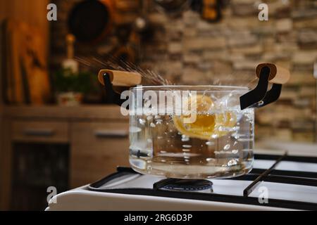 Immergere la pasta fettuccine in acqua bollente in una pentola Foto Stock