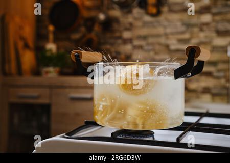 Immergere la pasta fettuccine in acqua bollente in una pentola Foto Stock