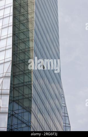 Una sola finestra aperta è un'onda solitaria nel mare di vetro sulla facciata East 28th Street della Prism Tower nel Nomad District di Manhattan. Foto Stock